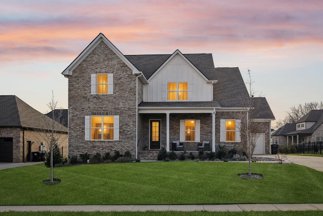 view of front facade with a lawn, a garage, and covered porch