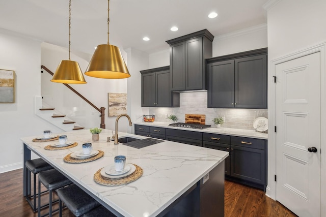 kitchen with light stone countertops, crown molding, sink, dark hardwood / wood-style floors, and hanging light fixtures