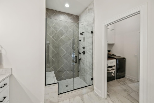 bathroom featuring washer / dryer, vanity, and a shower with door