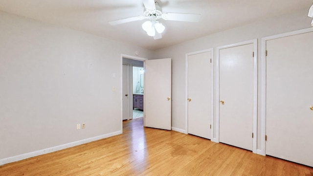 unfurnished bedroom with ceiling fan, light hardwood / wood-style floors, and two closets