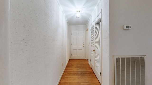 hallway featuring light hardwood / wood-style floors and crown molding