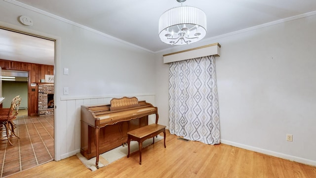 misc room featuring light wood-type flooring, a fireplace, ornamental molding, wooden walls, and a chandelier