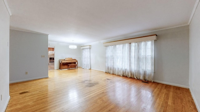 unfurnished living room with a chandelier, light hardwood / wood-style flooring, and crown molding