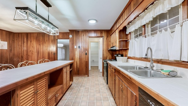 kitchen with sink, dishwashing machine, black range with electric cooktop, decorative light fixtures, and wooden walls