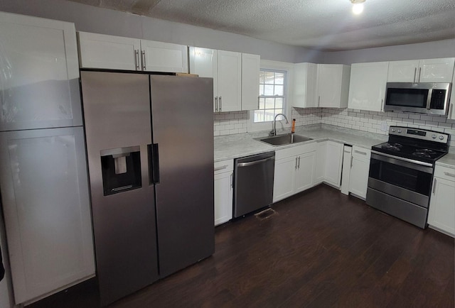 kitchen featuring stainless steel appliances, white cabinetry, and sink