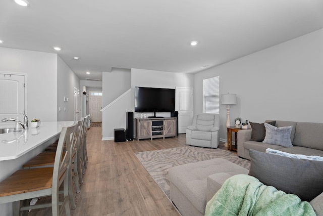 living room with sink and light hardwood / wood-style flooring