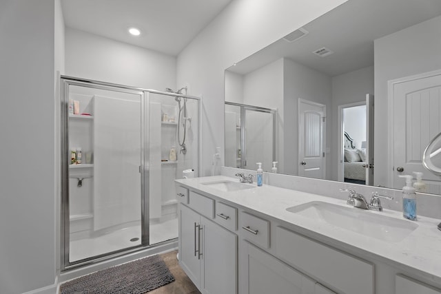 bathroom with vanity, an enclosed shower, and wood-type flooring