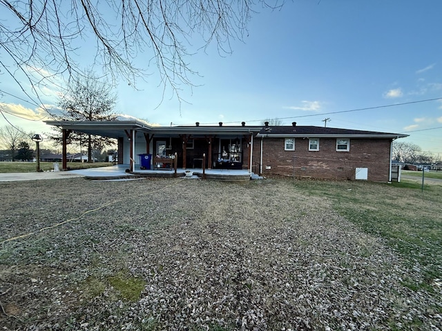 back of house with a lawn and a carport