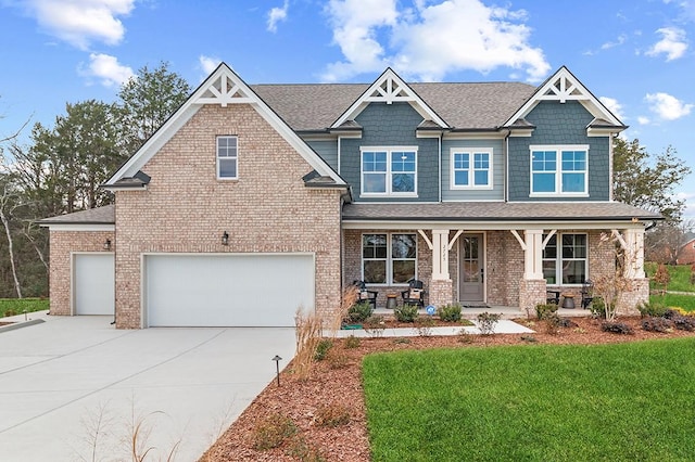 craftsman inspired home featuring covered porch, a garage, and a front yard