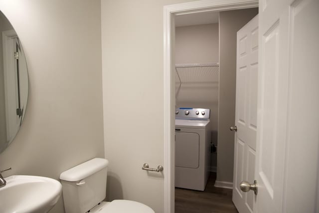 bathroom with wood-type flooring, washer / clothes dryer, toilet, and sink