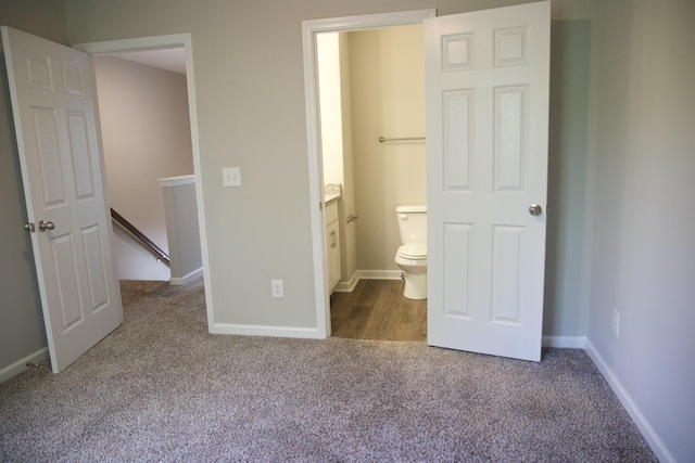 unfurnished bedroom with connected bathroom and carpet