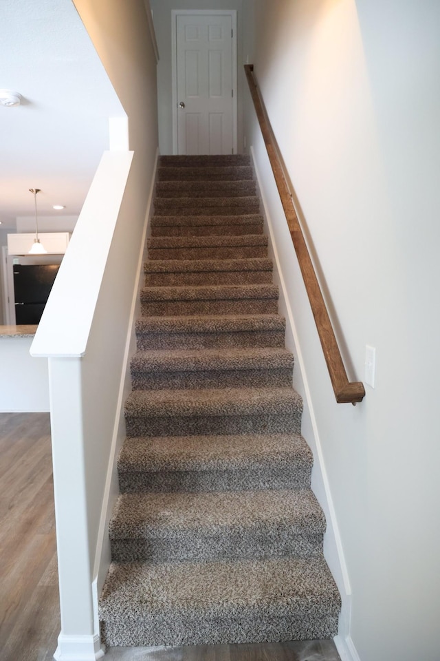 stairway with hardwood / wood-style flooring