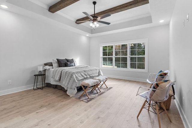 bedroom with a tray ceiling, ceiling fan, beamed ceiling, and light hardwood / wood-style floors