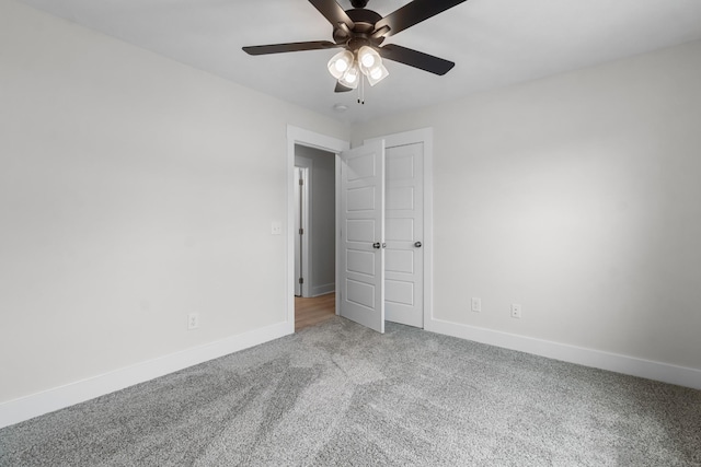 carpeted spare room featuring ceiling fan