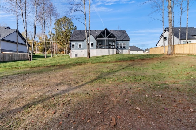 rear view of house with a lawn and a sunroom