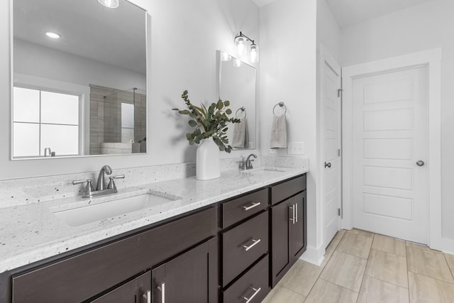 bathroom with tile patterned flooring, vanity, and walk in shower