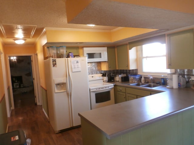 kitchen with sink, crown molding, green cabinetry, kitchen peninsula, and white appliances