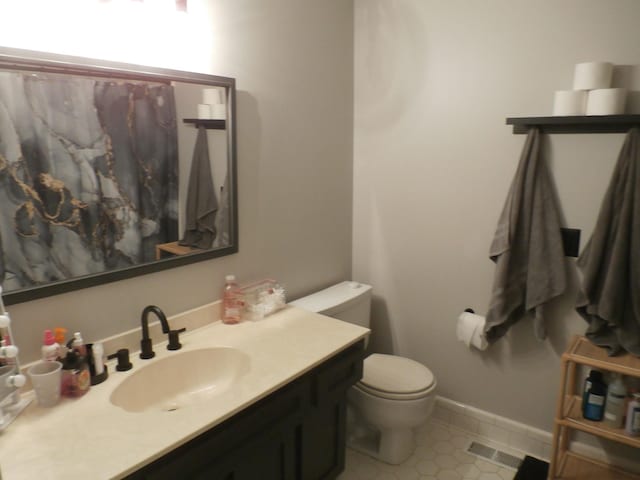 bathroom with vanity, toilet, and tile patterned flooring