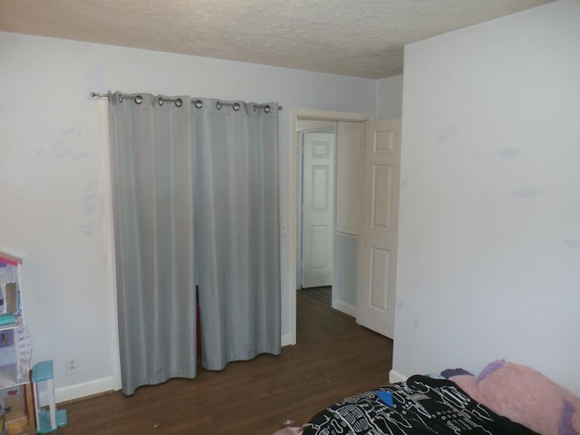 bedroom featuring dark hardwood / wood-style floors and a textured ceiling