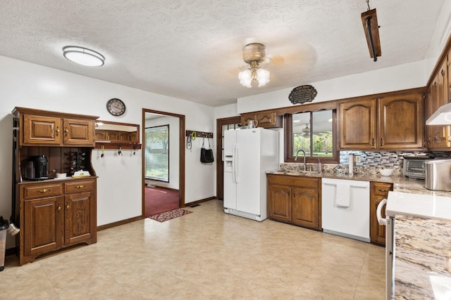 kitchen featuring backsplash, a textured ceiling, white appliances, ceiling fan, and sink