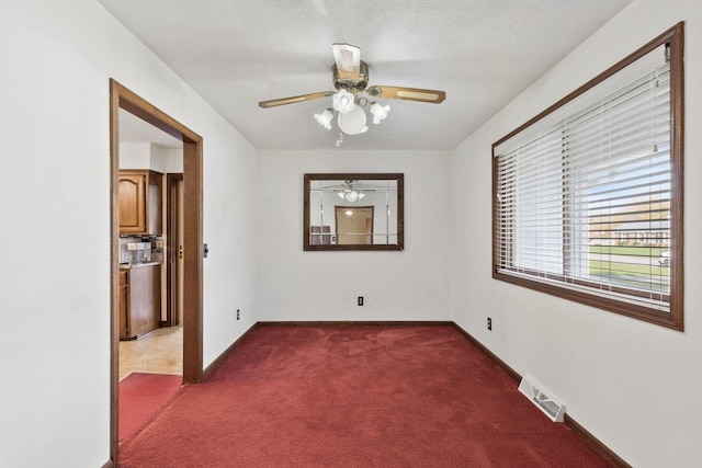 empty room featuring a textured ceiling and dark carpet