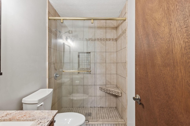 bathroom with vanity, toilet, a shower with door, and a textured ceiling