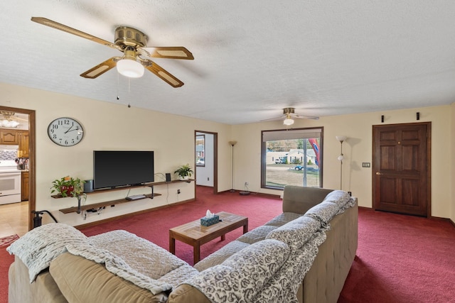 carpeted living room featuring ceiling fan and a textured ceiling