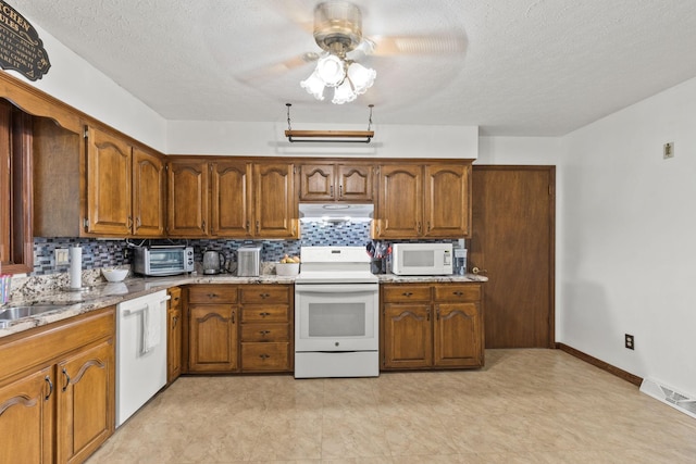 kitchen featuring a textured ceiling, decorative backsplash, ceiling fan, and white appliances