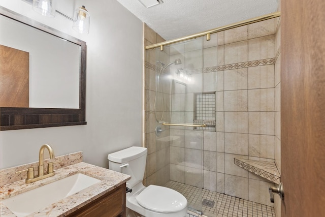 bathroom with vanity, a textured ceiling, toilet, and walk in shower