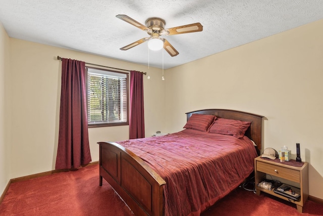 bedroom with dark colored carpet, ceiling fan, and a textured ceiling