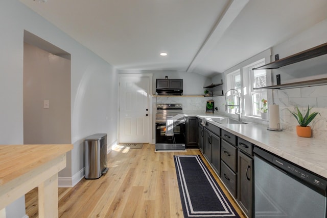 kitchen with sink, stainless steel appliances, light hardwood / wood-style flooring, lofted ceiling, and decorative backsplash