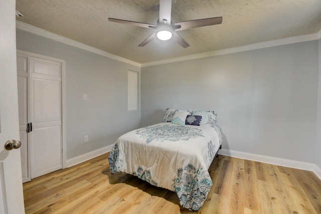 bedroom featuring light hardwood / wood-style flooring, ceiling fan, and crown molding