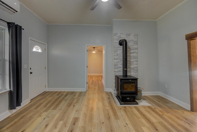 unfurnished living room featuring a wood stove, light wood-type flooring, and ornamental molding