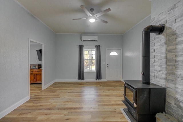 foyer featuring light wood-type flooring, ornamental molding, ceiling fan, an AC wall unit, and a wood stove