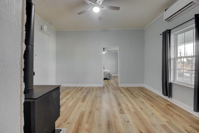 70 Laneview Concord Rd, Trenton, TN 38382 - spare room with ceiling fan, an AC wall unit, a wood stove, ornamental molding, and light wood-type flooring