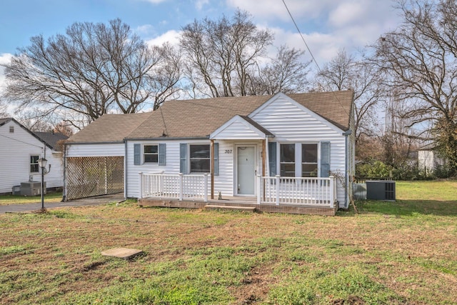 view of front of house with a front yard, a carport, and cooling unit