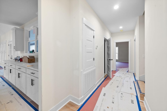 corridor with light hardwood / wood-style floors