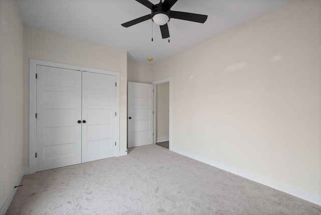 unfurnished bedroom featuring ceiling fan, a closet, and light colored carpet