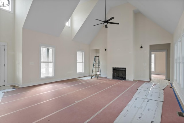 unfurnished living room featuring ceiling fan and high vaulted ceiling