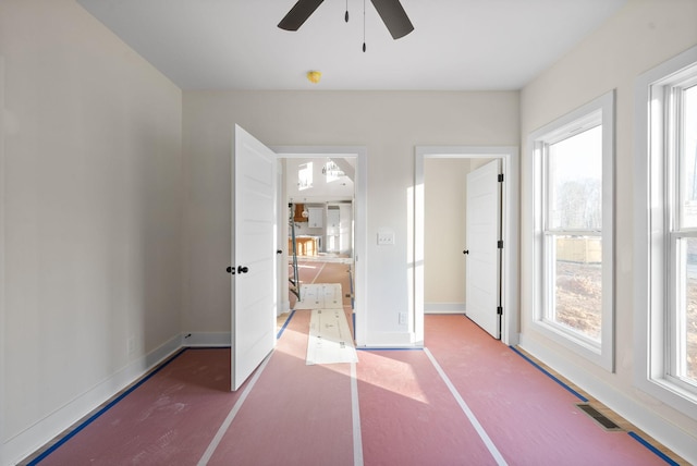 unfurnished bedroom with multiple windows and ceiling fan