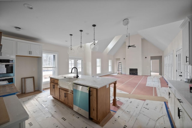 kitchen with white cabinets, a center island with sink, and dishwasher