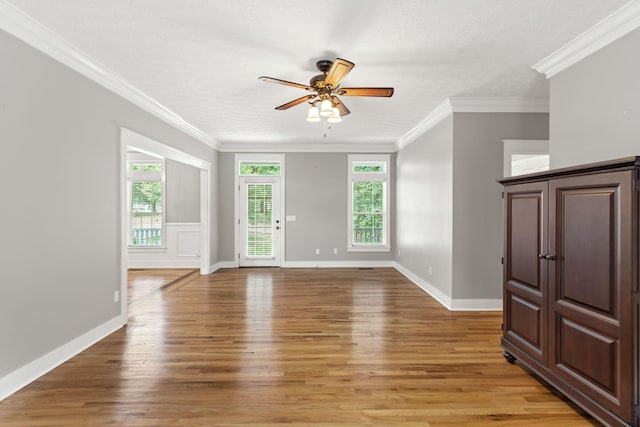 unfurnished living room featuring crown molding, a wealth of natural light, and light hardwood / wood-style flooring