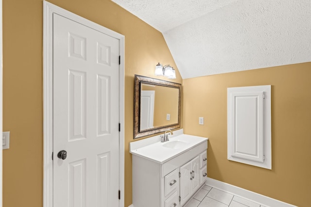 bathroom with vanity, a textured ceiling, lofted ceiling, and tile patterned flooring