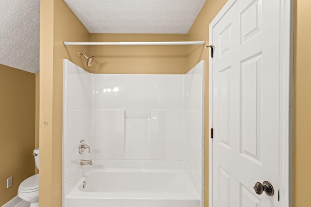 bathroom with tub / shower combination, a textured ceiling, and toilet