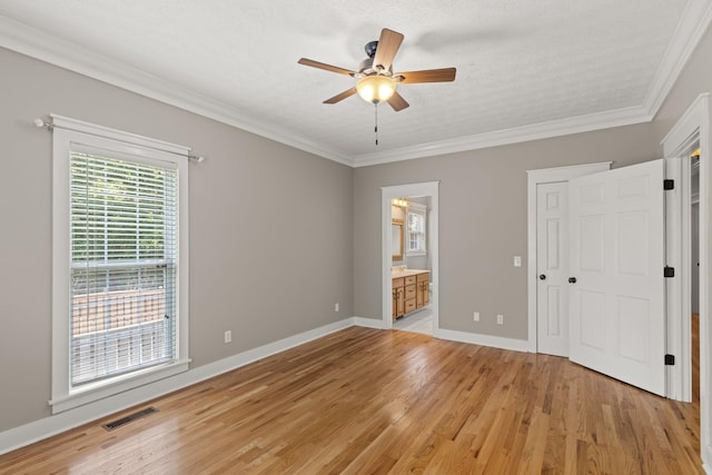 unfurnished bedroom with connected bathroom, ceiling fan, light hardwood / wood-style flooring, a textured ceiling, and ornamental molding