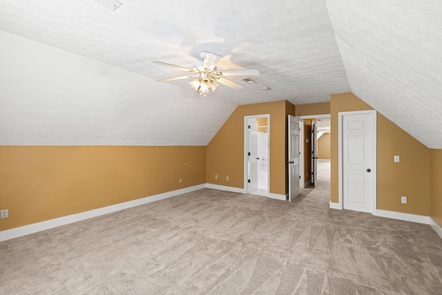 bonus room featuring a textured ceiling, light carpet, and vaulted ceiling