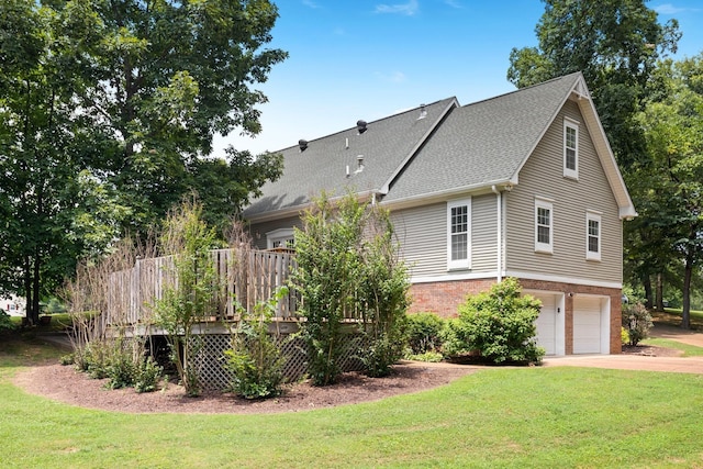 exterior space with a lawn, a garage, and a deck