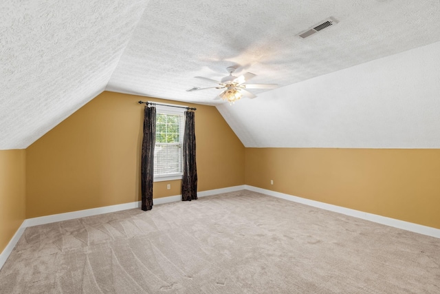 bonus room with ceiling fan, light colored carpet, a textured ceiling, and vaulted ceiling