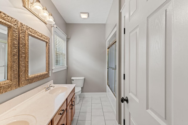 full bathroom featuring combined bath / shower with glass door, vanity, tile patterned floors, and toilet