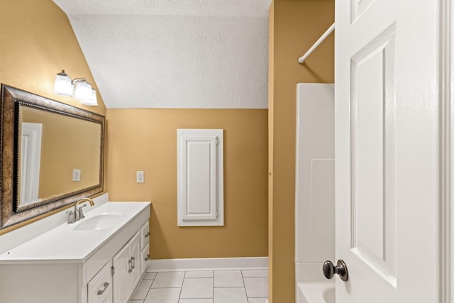 bathroom featuring tile patterned floors, vanity, a textured ceiling, washtub / shower combination, and lofted ceiling